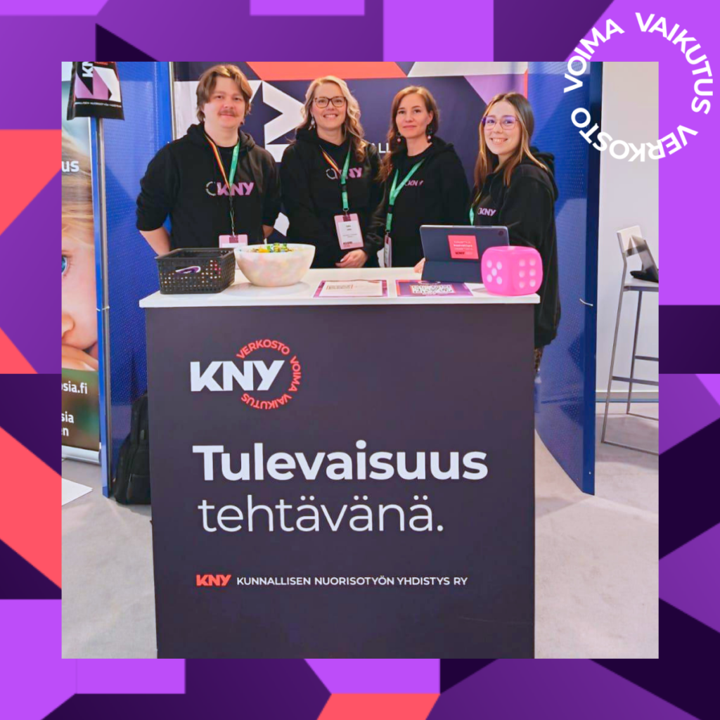 Kuvassa KNY-tiimi Riku, Salla, Saara ja Kati seisoo esittelypisteen edessä